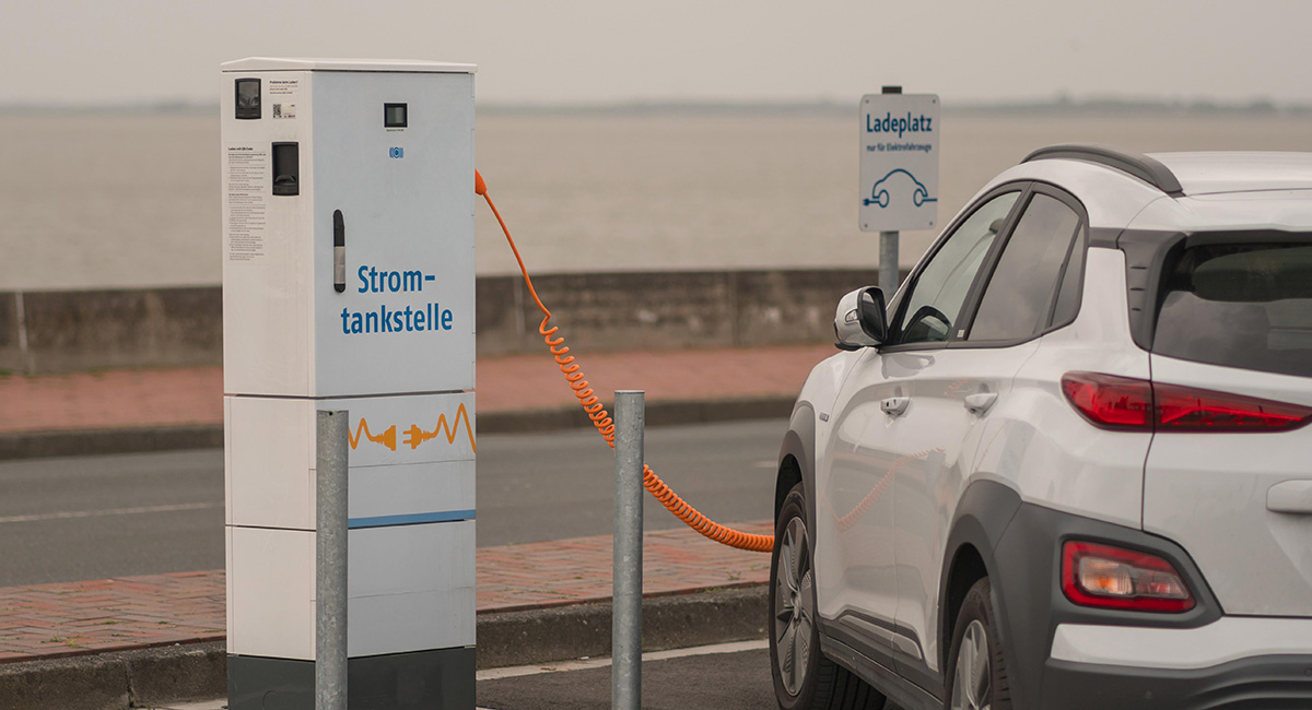 Eine öffentliche Ladesäule, an der ein E-Auto Strom tankt.