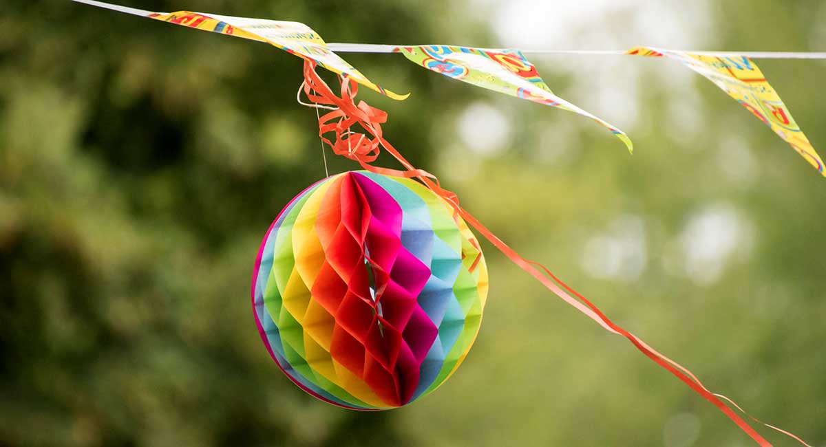 Ein Lampion aus buntem Papier, Wimpel und Luftschlangen wehen im Wind.