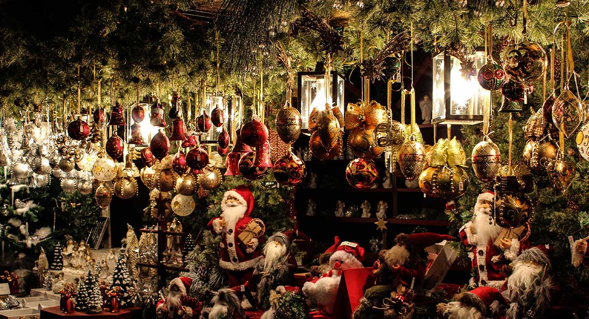 Stand auf einem Weihnachtsmarkt mit viel Tannengrün, Weihnachtskugeln und Weihnachtsmännern.