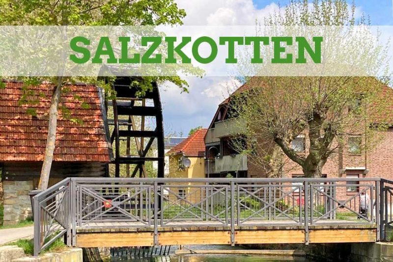 Brücke über die Heder in Salzkotten mit Kunstrad im Bildhintergrund.