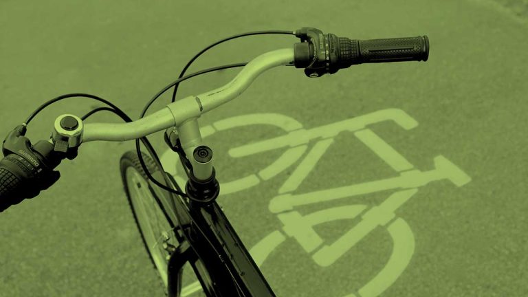 Aufsicht auf ein Radweg Piktogramm mit einem Fahrrad im Vordergrund.