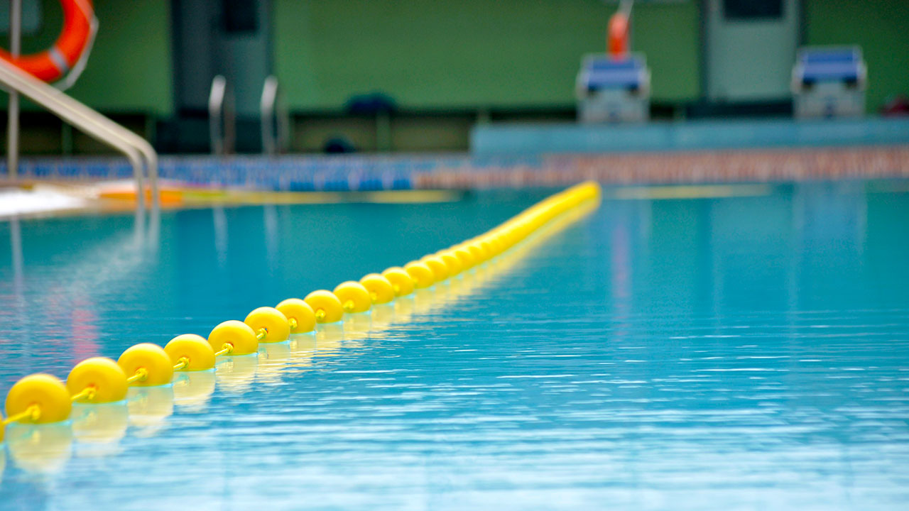 Ein Hallenbad mit einer gelben Kette im Schwimmbecken.
