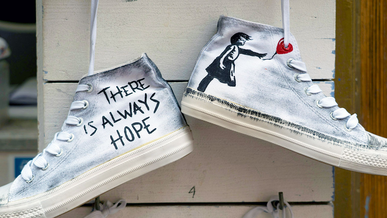 Ein Paar aufgehängte Turnschuhe mit der Aufschrift „There is always Hope“.