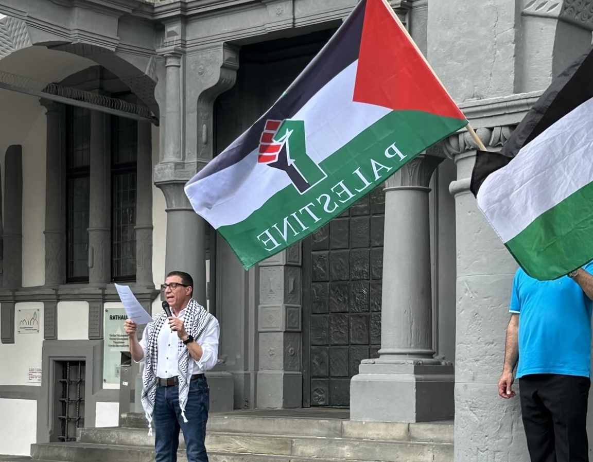 Redner mit einer Palästinafahne vor dem Rathaus