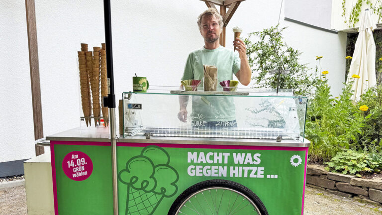 Grüner Eiswagen mit der Aufschrift „Macht was gegen Hitze …“