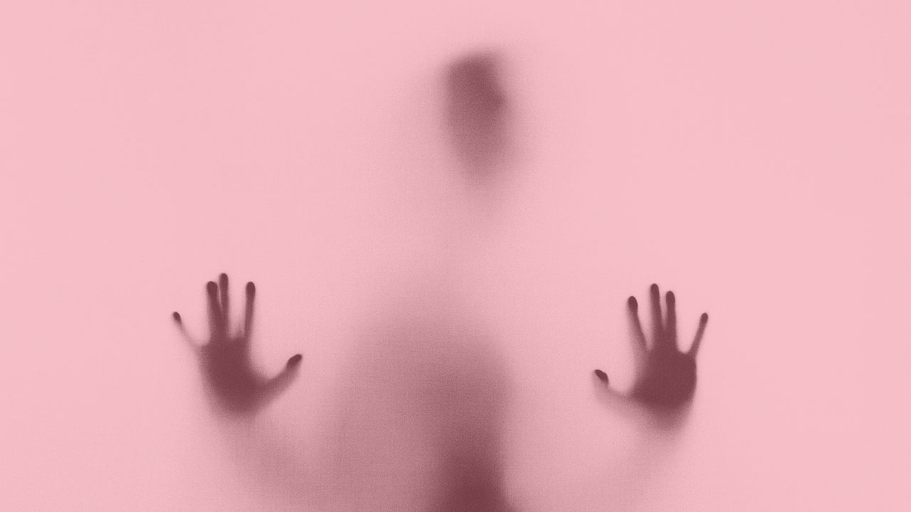 Schattenriss eines Menschen hinter einer Glasscheibe.