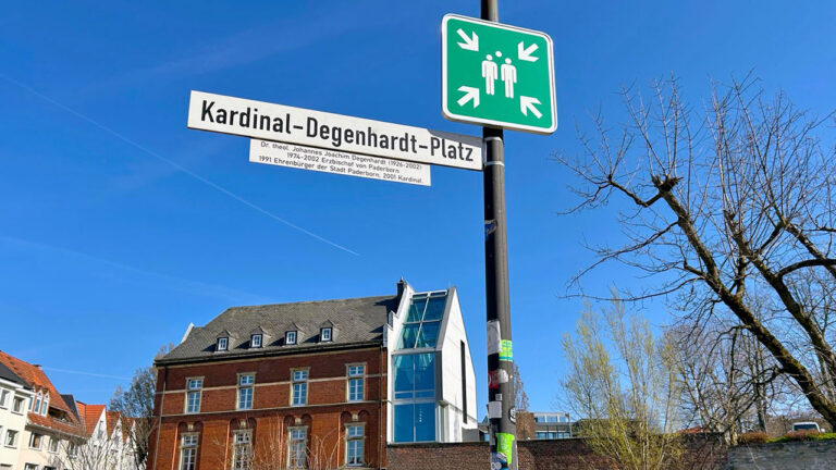 Beschilderung des „Kardinal-Degenhardt-Platzes“ vor blauem Himmel.