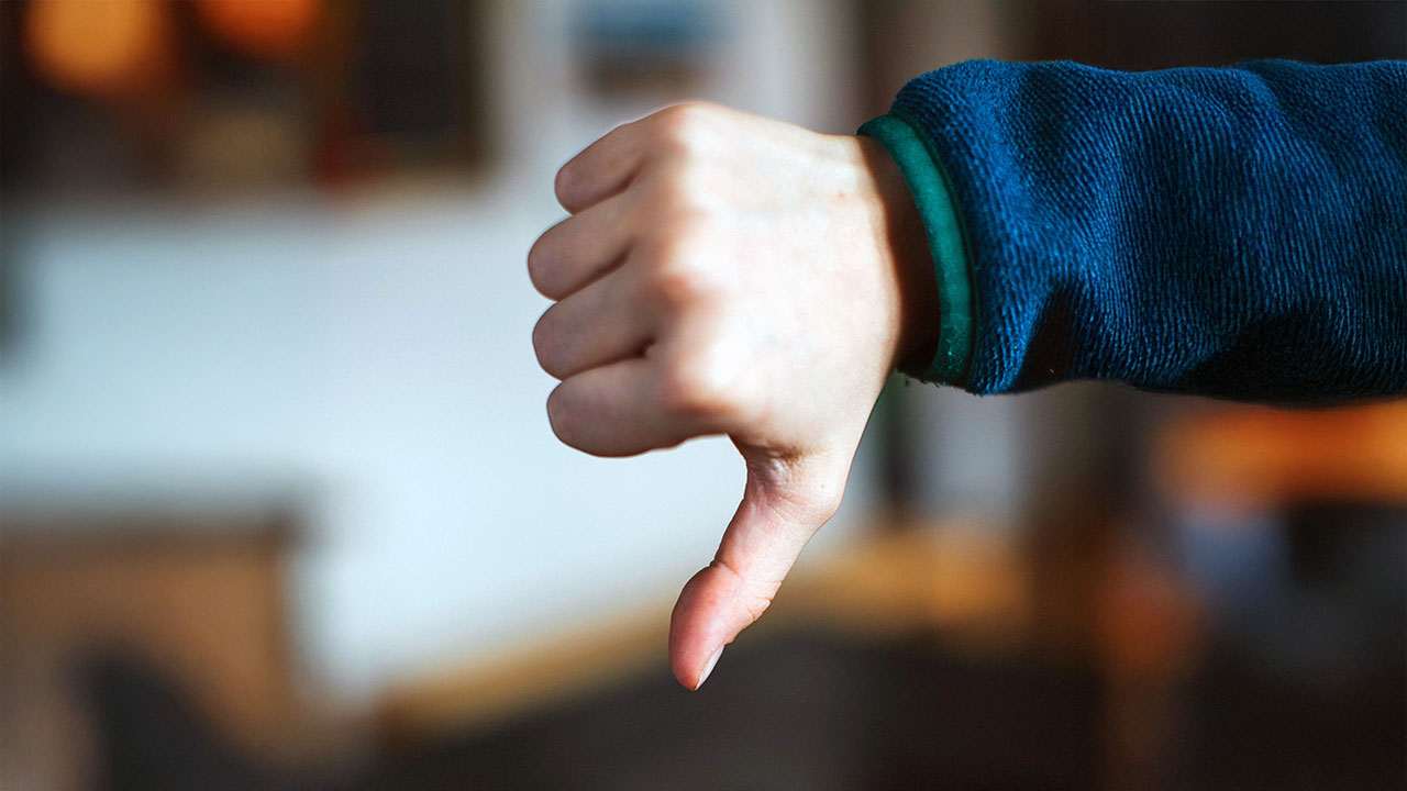 Eine Hand mit einem nach unten weisenden Daumen.
